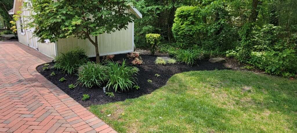 Freshly mulched beds edged against a brick walkway