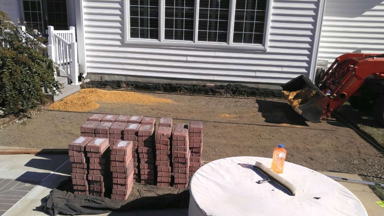 Excavated trench along a house foundation during drainage work