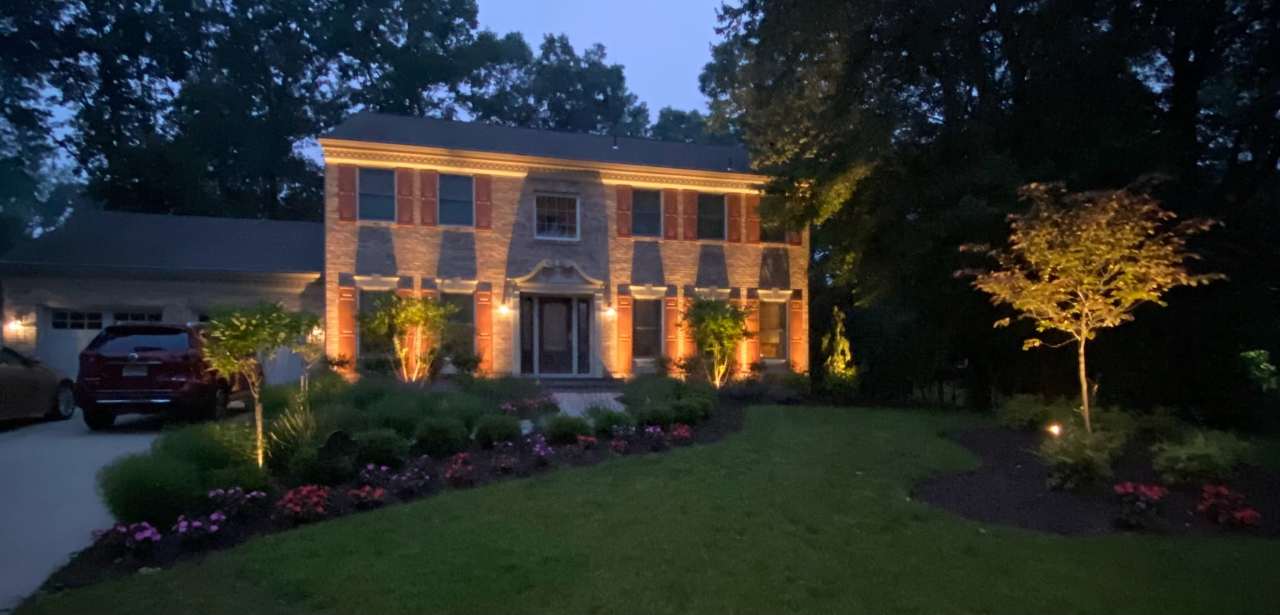 Two-story facade uplit in warm amber at dusk
