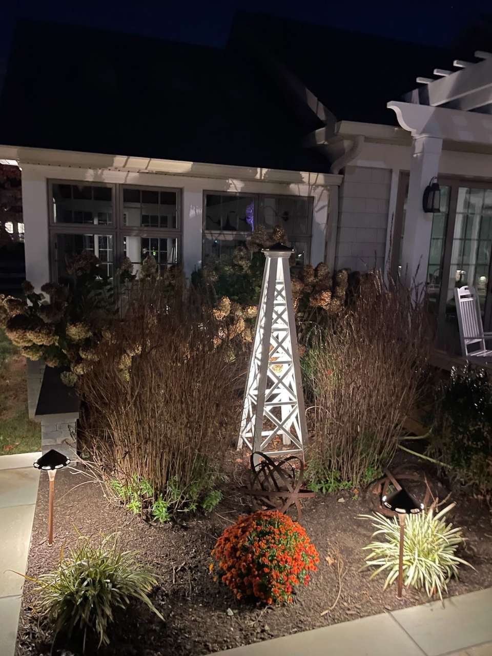 Fall mums and grasses around a garden obelisk