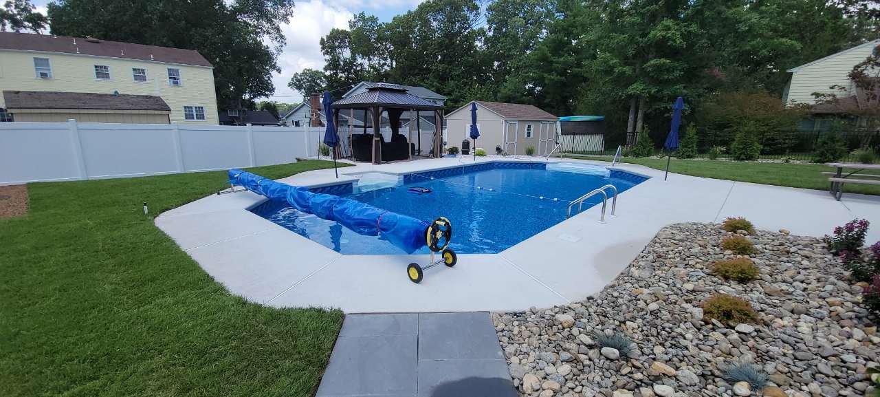Finished lawn, pool and gazebo with river-rock border