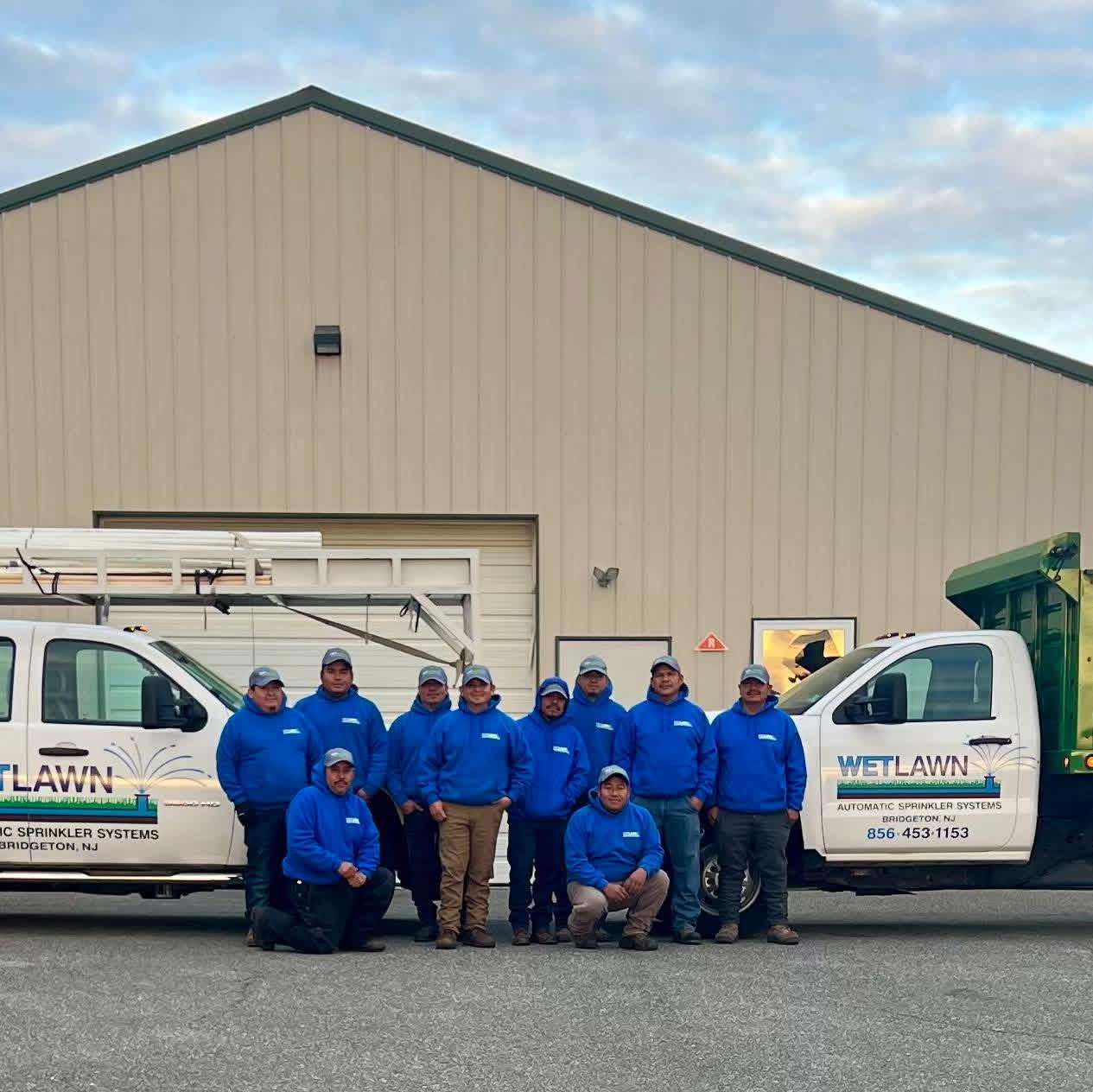 The Wetlawn crew standing in front of the company trucks
