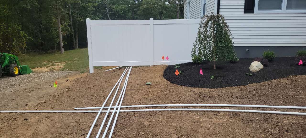 Irrigation lines laid out across a graded yard