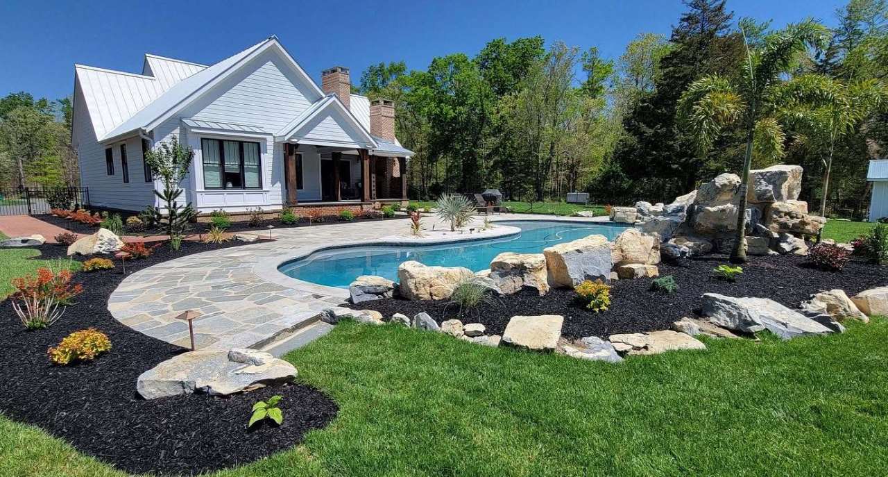 Natural stone poolscape, boulder wall and flagstone walk installed by Wetlawn