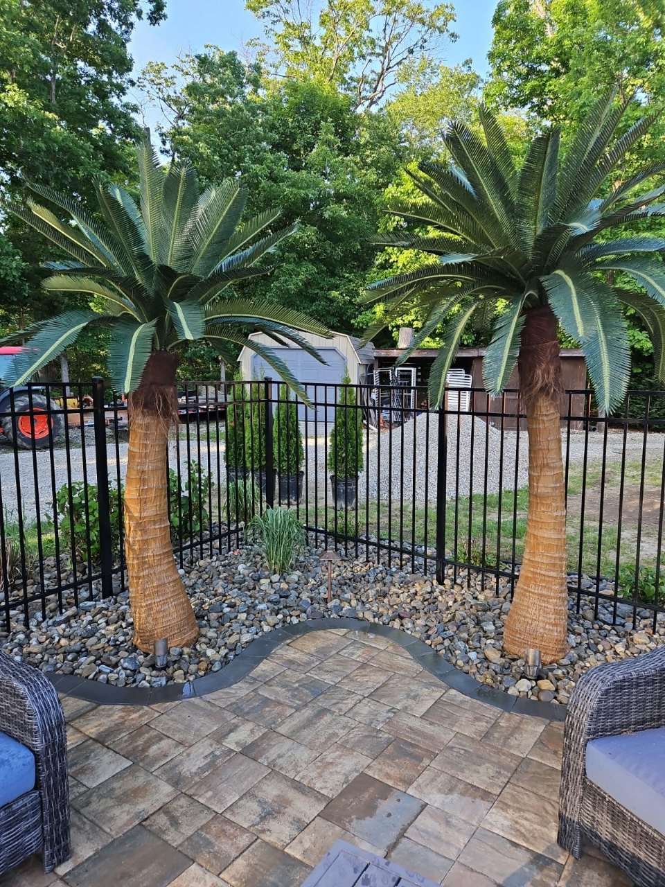 Paver patio with palms and iron fencing
